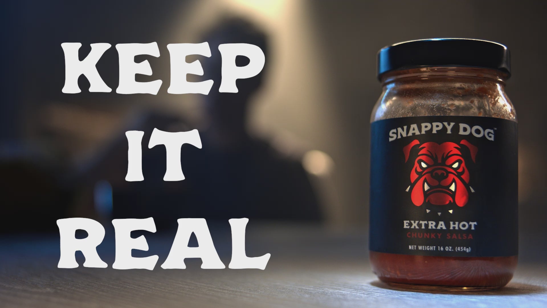 Load video: Snappy Dog Salsa sitting on a table with the text, &quot;Keep It Real&quot; on the screen.